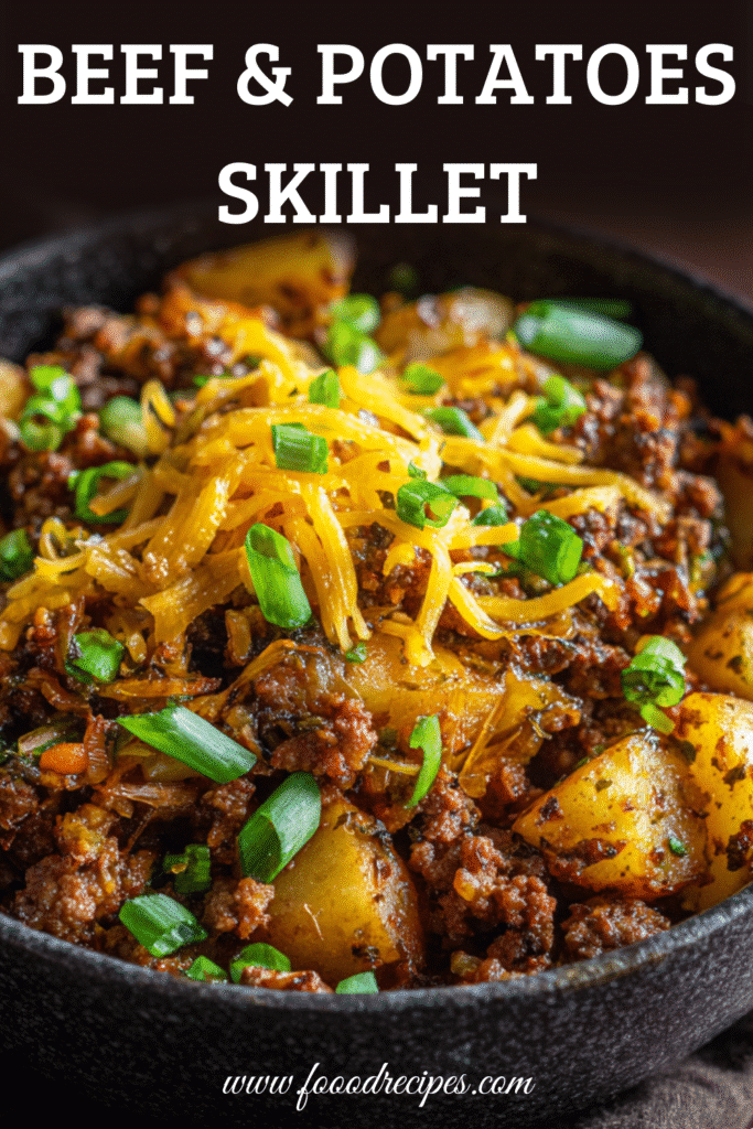 Ground beef and potatoes skillet topped with cheddar and green onions in a black bowl